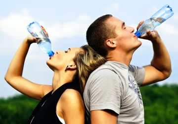 a couple drinking water after a workout