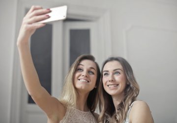 a pair of young women taking a selfie