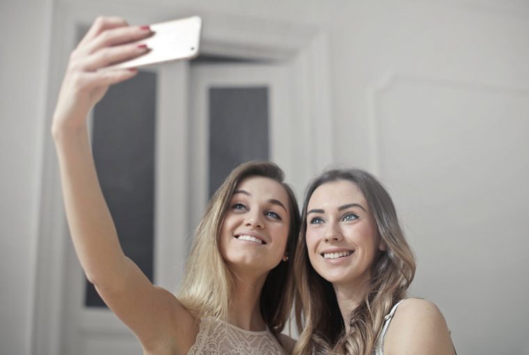 a pair of young women taking a selfie