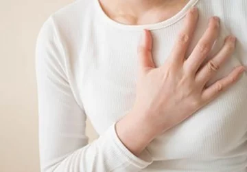 a woman holding her chest in pain