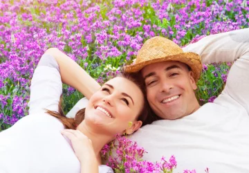 a couple laying in a field of flowers