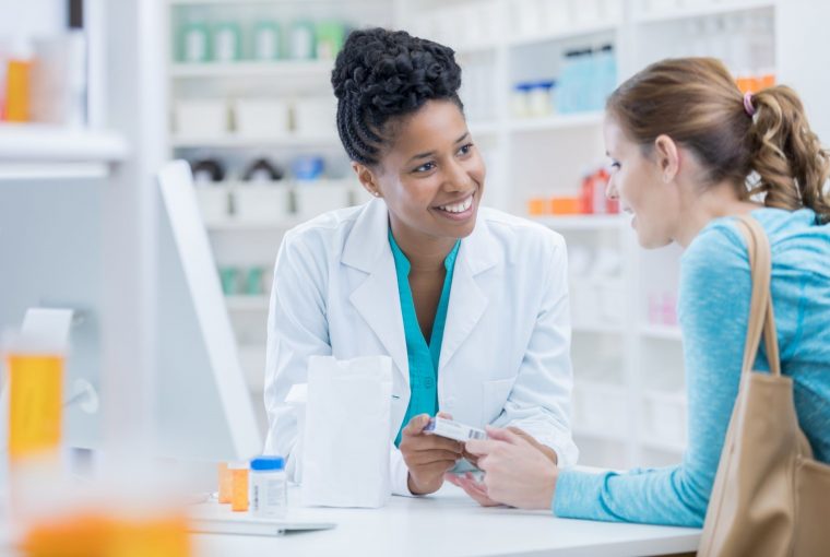 a woman talking to a pharmacist