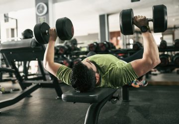 a man doing chest press in the gym