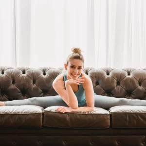 a woman doing the splits on a couch