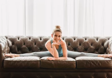 a woman doing the splits on a couch