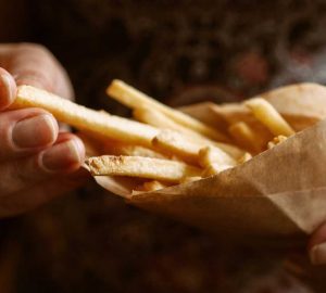 a person eating a bunch of fries