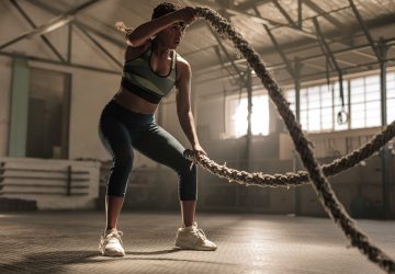 a woman exercising with battle ropes