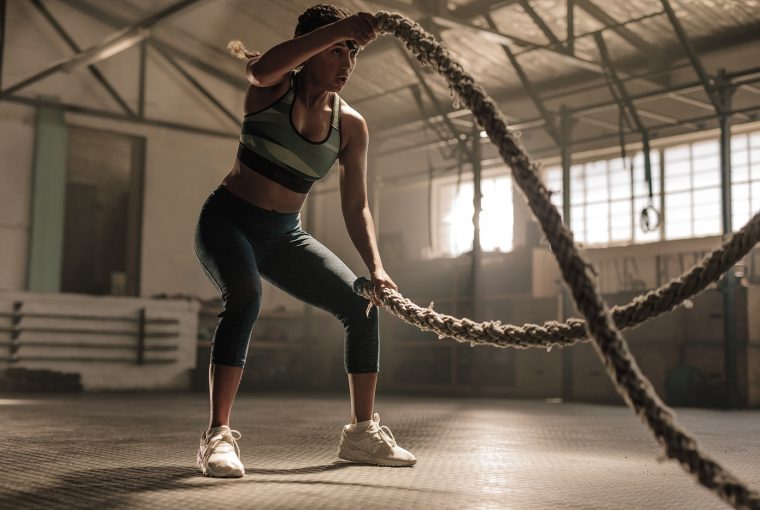 a woman exercising with battle ropes