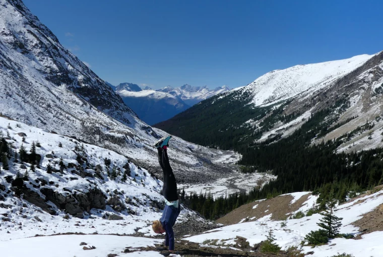 a woman doing a handstand in the mountains