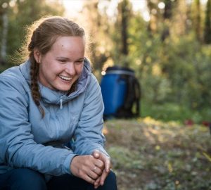 a woman smiling while sitting outside