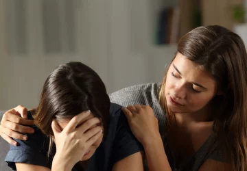 a woman comforting another woman who is crying