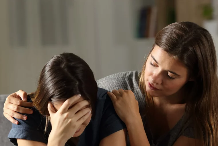 a woman comforting another woman who is crying