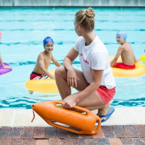 a lifeguard watching some children swimming