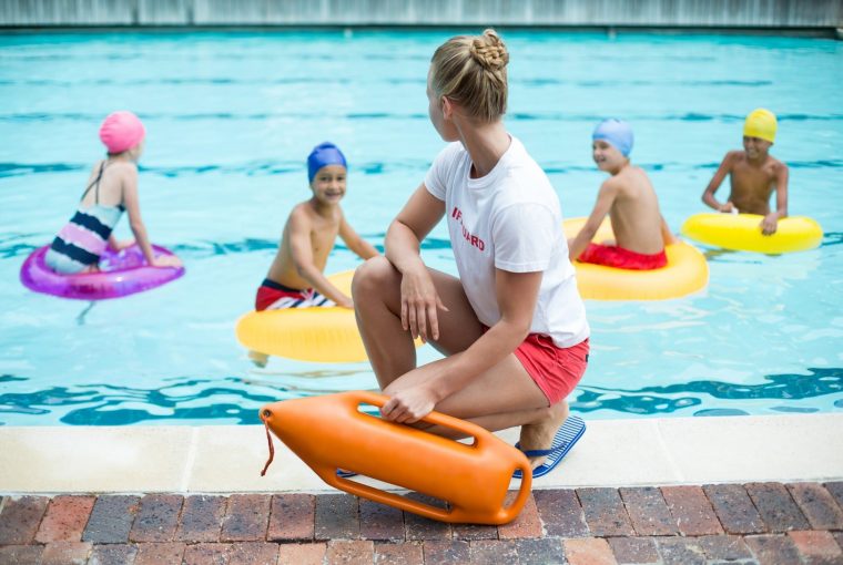 a lifeguard watching some children swimming