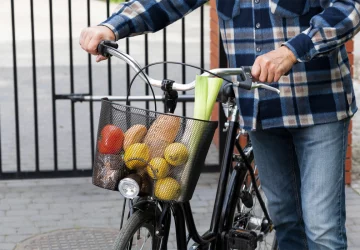 a man carrying groceries in his bike basket