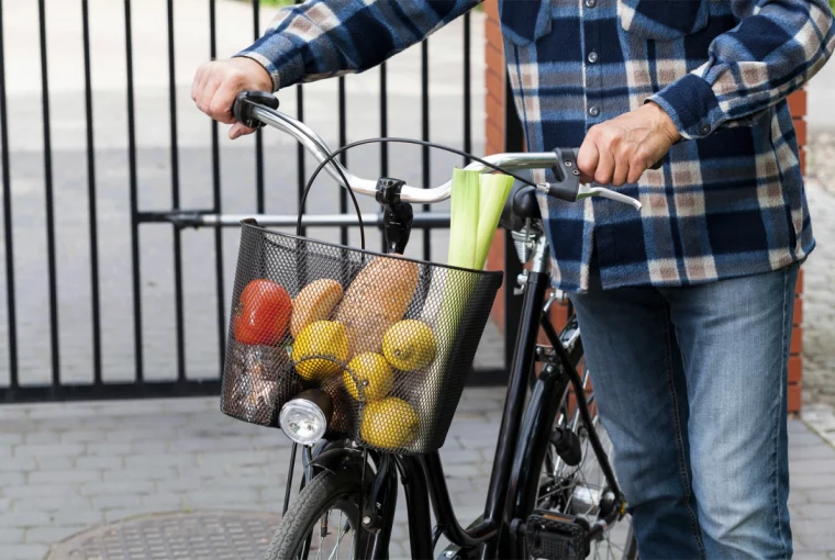 a man carrying groceries in his bike basket