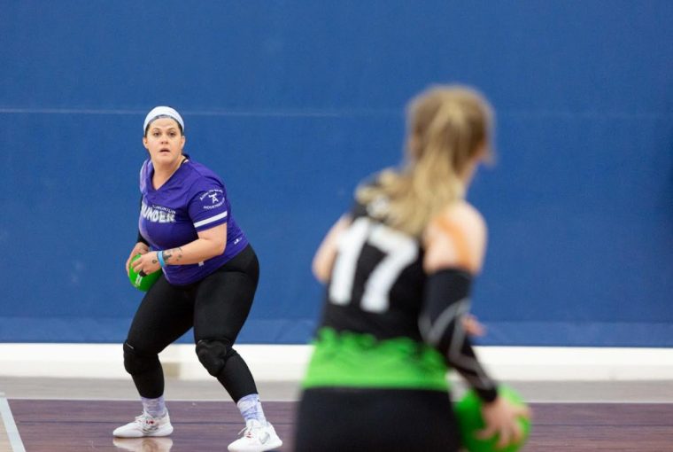 a woman getting ready to throw a dodgeball