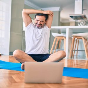 a man stretching in front of the computer