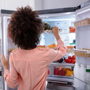 a woman looking for something to eat in the fridge