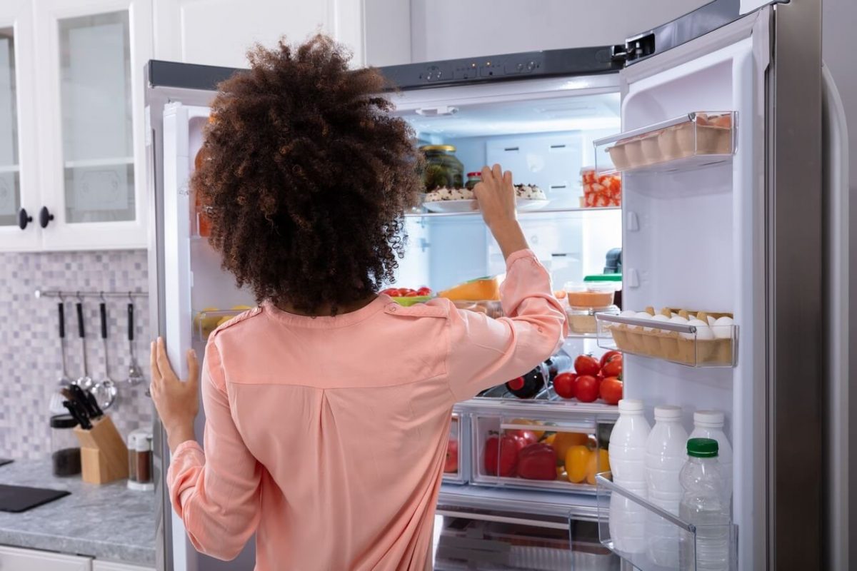 a woman looking for something to eat in the fridge