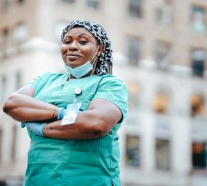 a female nurse in her uniform standing in front of a building