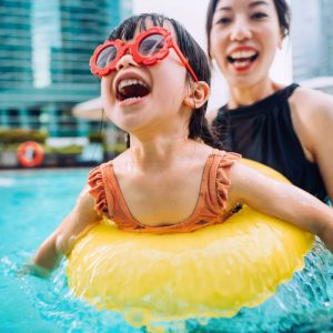 a woman swimming with her child