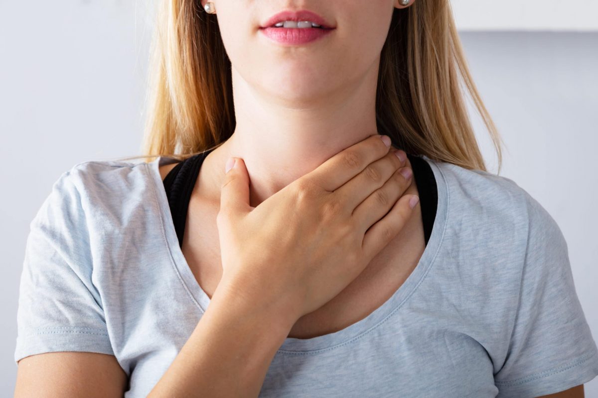 a woman holding her thyroid