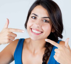 a woman pointing at her white smile