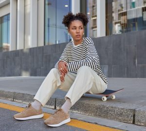a woman sitting on a curb with great street style
