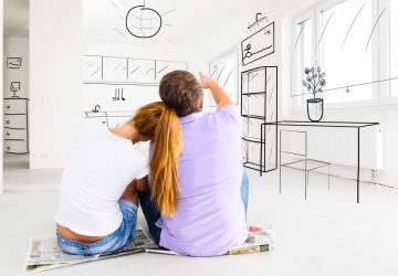 a couple sitting on the floor in their home looking at the interior