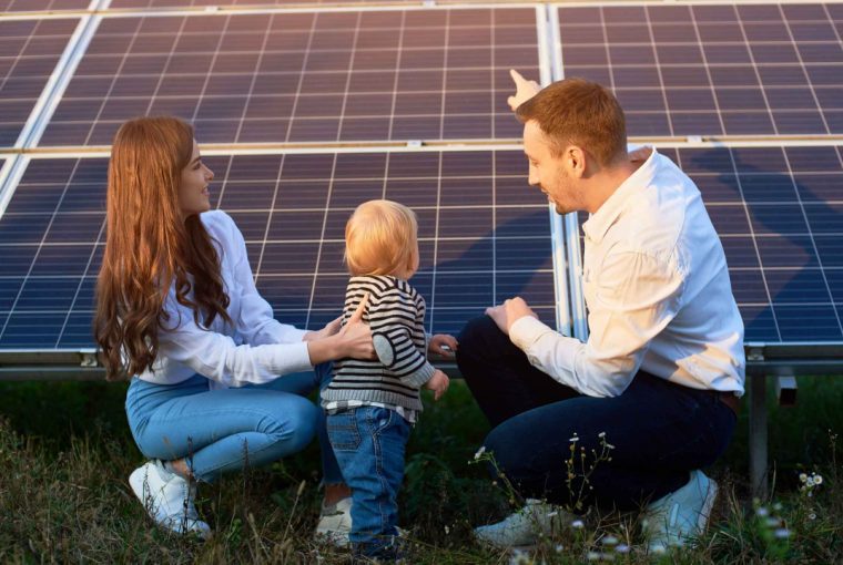 a family outdoors looking at their solar panels