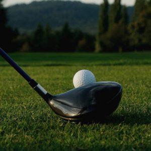 a golf ball lined up with a driver