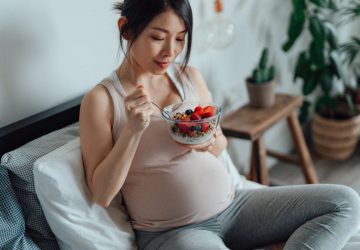 a pregnant woman eating a healthy breakfast