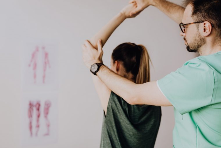 a patient recieving a chiropractic treatment with their arm above their head