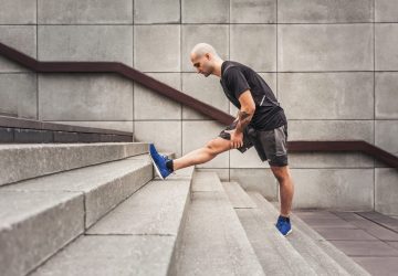 a man doing a hamstring stretch on some stairs