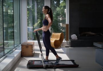 a woman walking on a foldable treadmill
