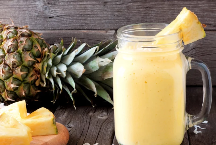 a photo of a smoothie with a pineapple in the background