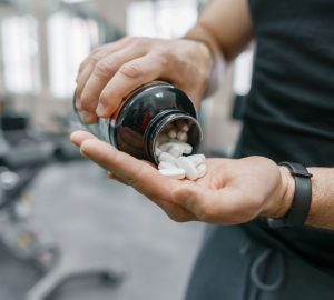 a man pouring supplements out of a bottle