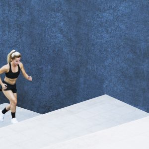a woman sunning up some stairs against a dark blue background