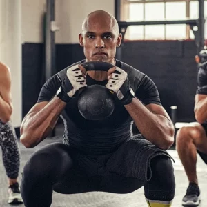 a group of athletes using kettlebells for a workout