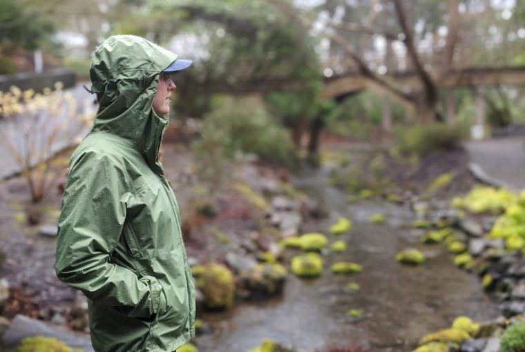 a person exploring the outdoors wearing a rain coat