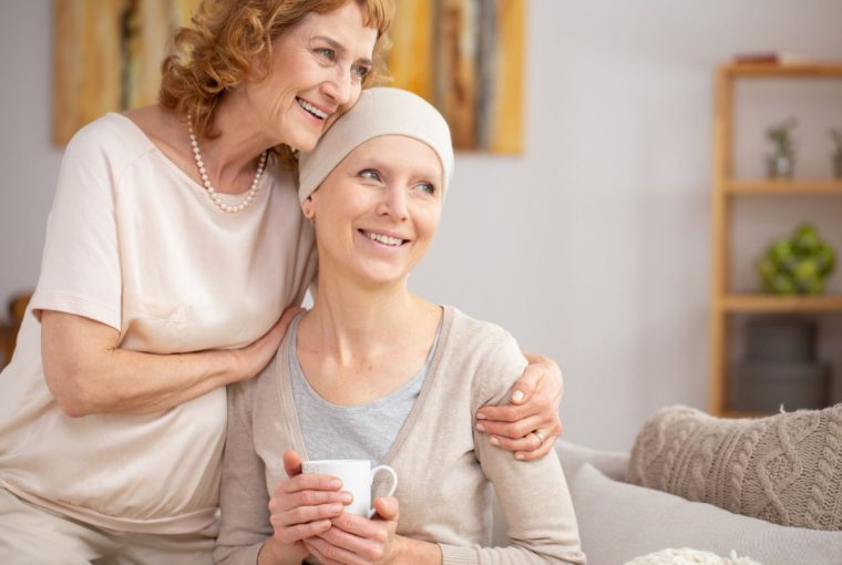 a woman with a scarf on her hear being hugged by another woman