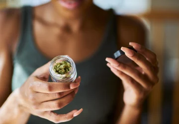 a woman opening a bottle of cannabis products