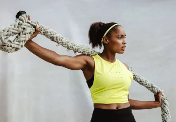 a woman stretching with a battle rope