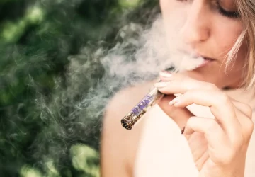 a woman using a vape pen