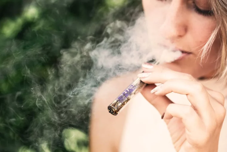 a woman using a vape pen