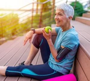 a woman sitting outside eating an apple