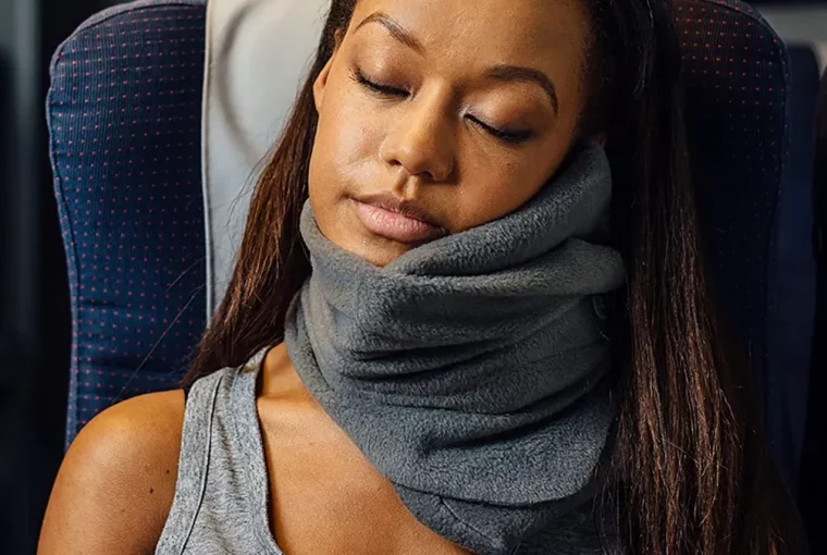 a woman using a travel pillow