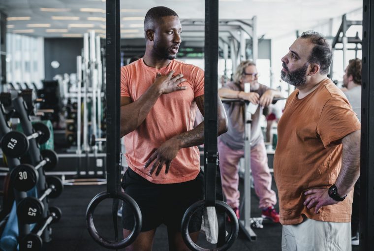 a trainer talking to a client in the gym