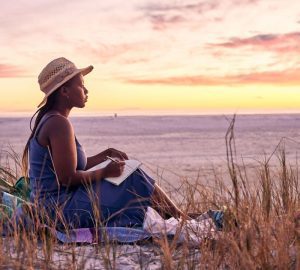 a woman sitting outside during a sunset